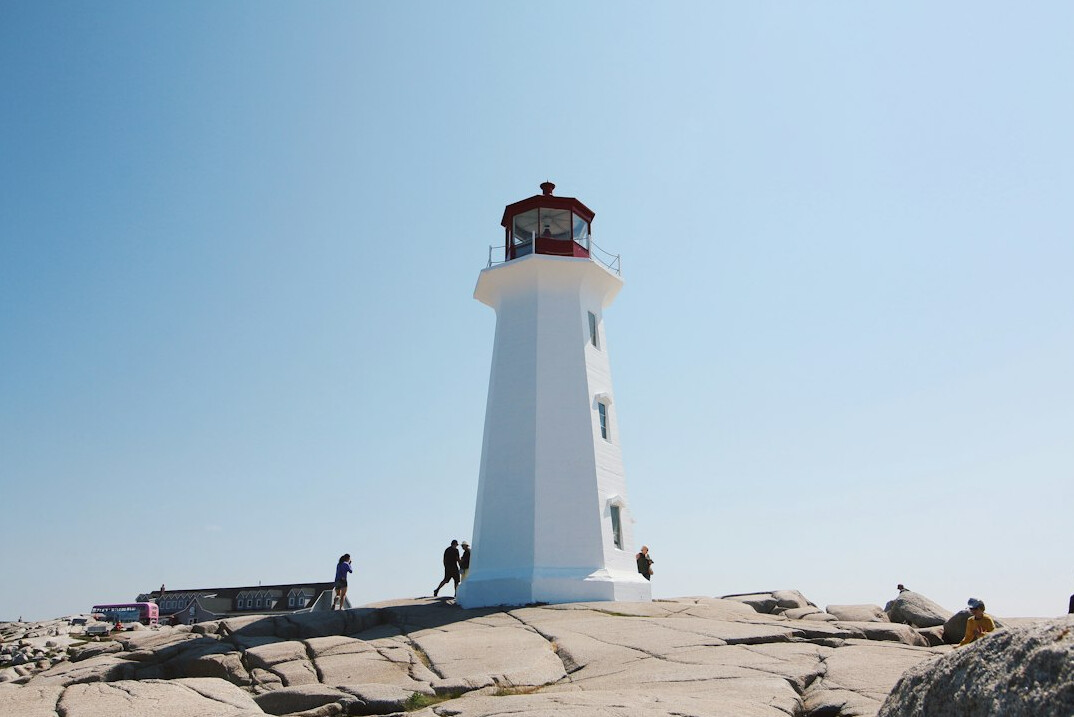 Red and white lighthouse on a rocky Nova Scotia coastline