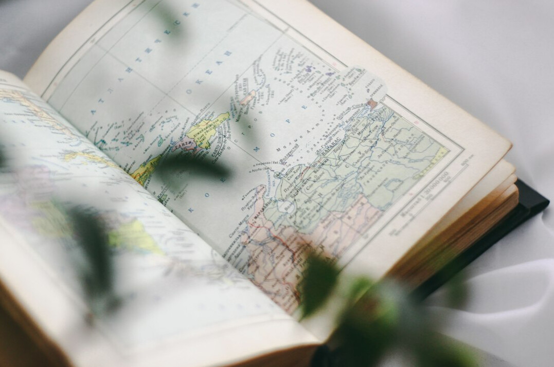 Vintage camera resting on an open travel journal with a map