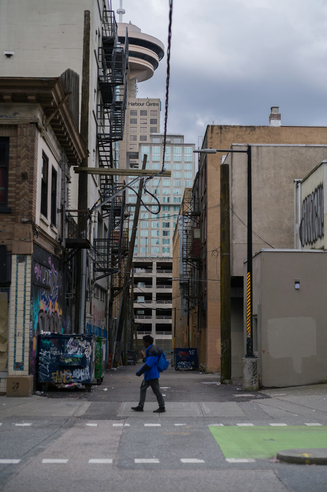 Photographer walking down a quiet Canadian city street with a camera