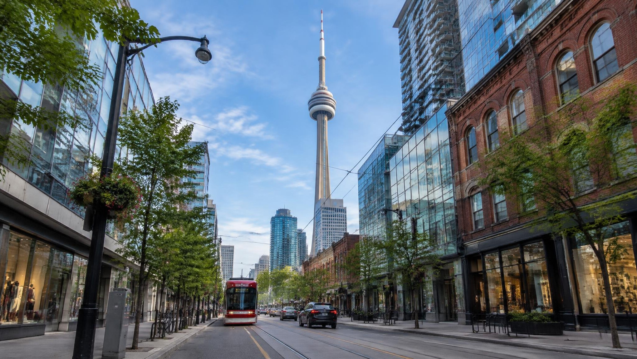 Toronto city street with the CN Tower rising above downtown buildings